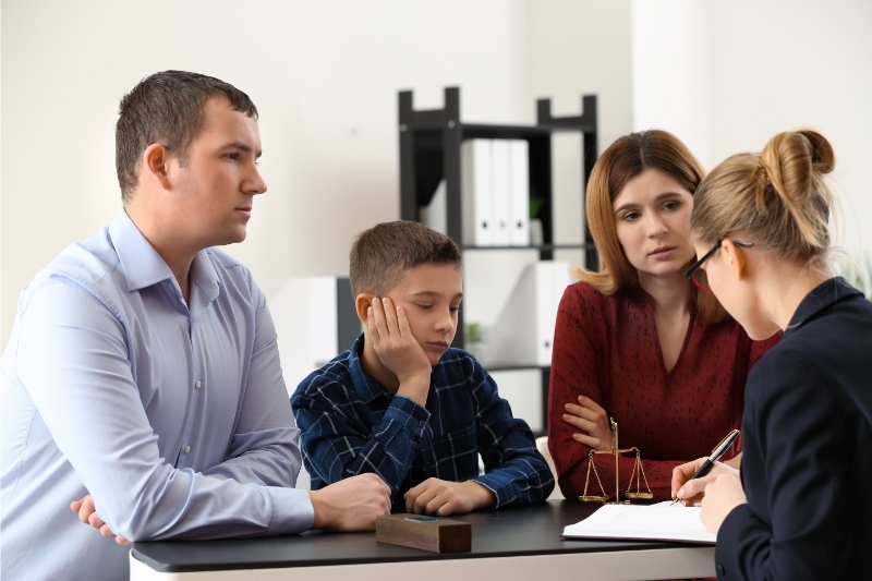 An image of a de facto relationship family discussing their case with the lawyer.