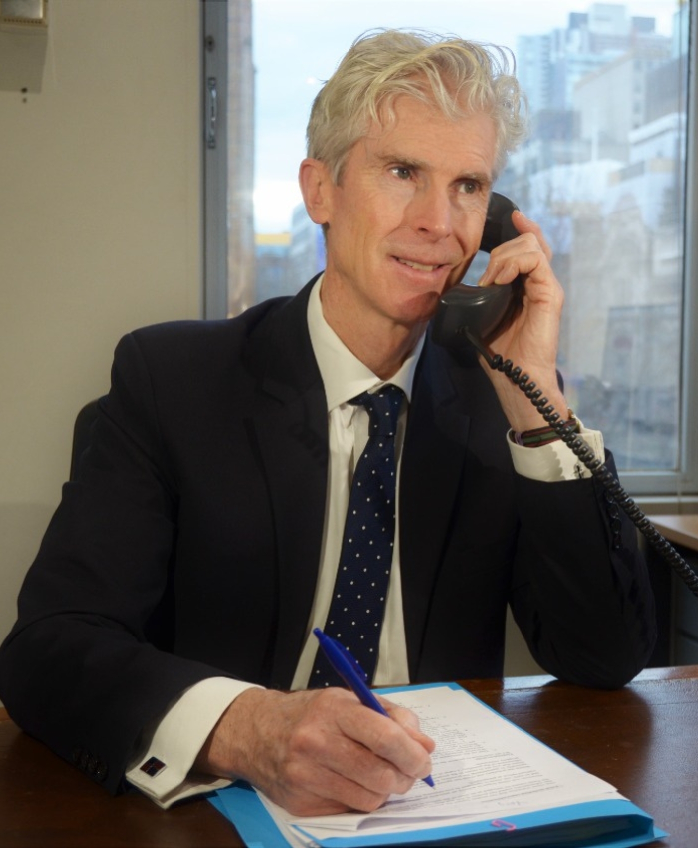 An image of Rowan Skinner who is an experienced property settlement lawyer hearing out a property settlement case over the phone.