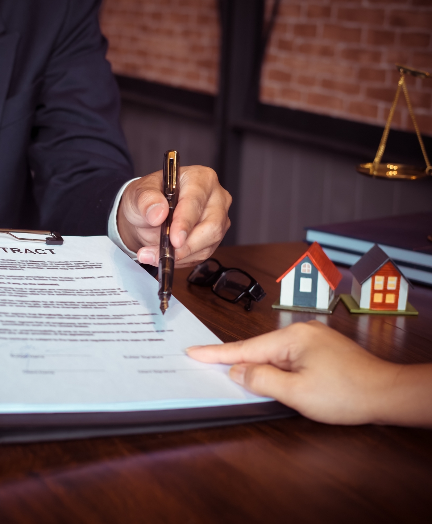 An image of a property settlement lawyer signing a contract with the client to take up their case.